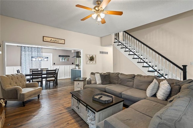 17507 E 35th Ter, Independence, MO 64055 - living room with stairway, dark wood finished floors, a ceiling fan, a textured ceiling, and wainscoting