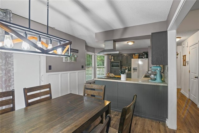 17507 E 35th Ter, Independence, MO 64055 - dining area featuring wood finished floors, a textured ceiling, and wainscoting