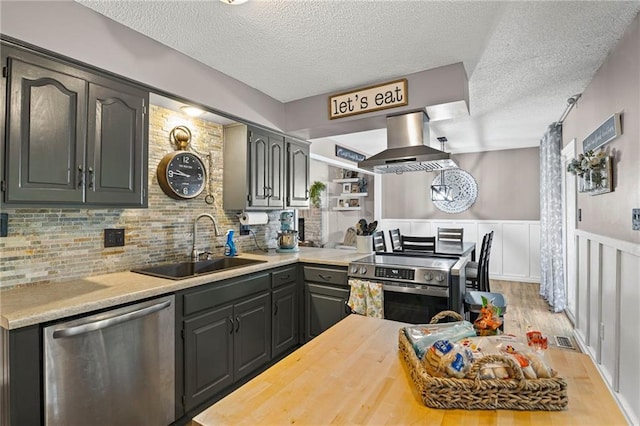 17507 E 35th Ter, Independence, MO 64055 - kitchen with stainless steel appliances, island range hood, a textured ceiling, wood finished floors, and tasteful backsplash