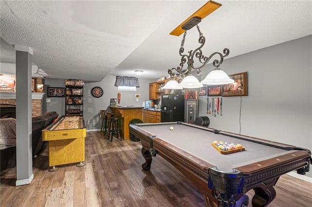 17507 E 35th Ter, Independence, MO 64055 - playroom with light wood-type flooring, billiards table, bar with sink, a textured ceiling, and a fireplace