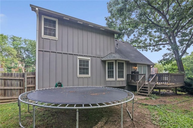 17507 E 35th Ter, Independence, MO 64055 - back of property with a trampoline, board and batten siding, a deck, and roof with shingles