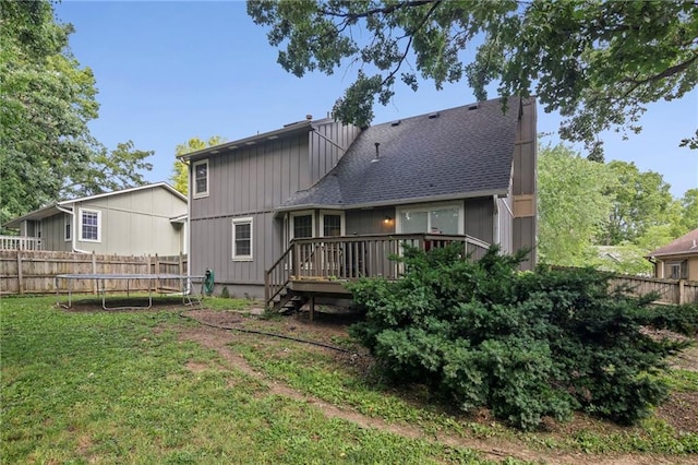 17507 E 35th Ter, Independence, MO 64055 - rear view of property with a trampoline, a fenced backyard, a deck, and board and batten siding