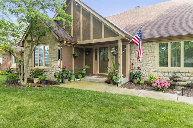 2005 NW Fawn Dr, Blue Springs, MO 64015 - tudor-style house with stone siding, roof with shingles, a front yard, and stucco siding