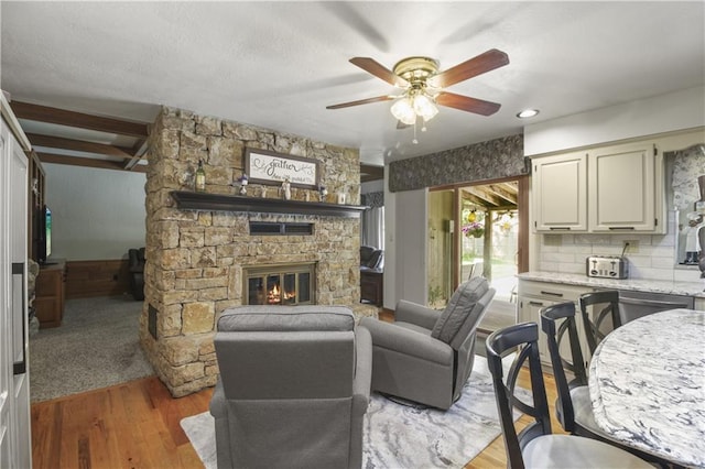 2005 NW Fawn Dr, Blue Springs, MO 64015 - living room with ceiling fan, a fireplace, light wood-style flooring, and beam ceiling