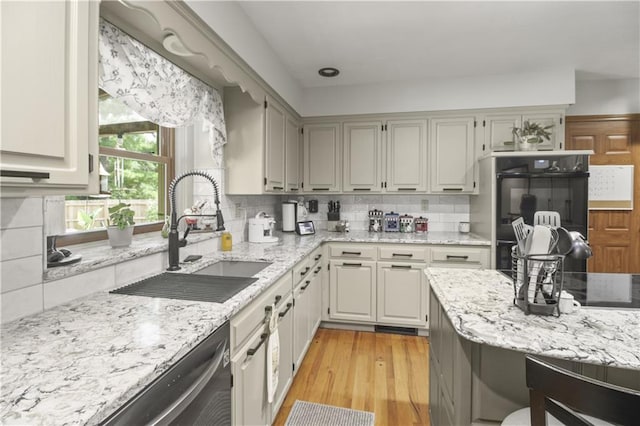2005 NW Fawn Dr, Blue Springs, MO 64015 - kitchen with dishwasher, light wood-style flooring, light stone counters, and decorative backsplash