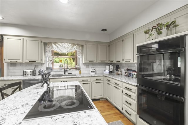 2005 NW Fawn Dr, Blue Springs, MO 64015 - kitchen featuring black appliances, backsplash, light stone countertops, and recessed lighting