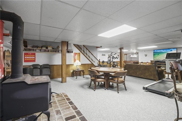 2005 NW Fawn Dr, Blue Springs, MO 64015 - dining room featuring a paneled ceiling, carpet, a wood stove, stairway, and a wainscoted wall