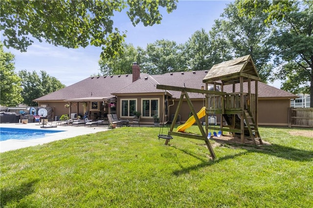 2005 NW Fawn Dr, Blue Springs, MO 64015 - back of house with a patio area, a playground, and a chimney