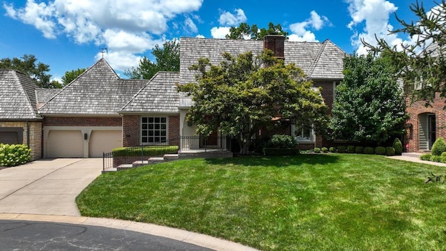 28 Le Mans Ct, Prairie Village, KS 66208 - view of front of property featuring brick siding, an attached garage, a front yard, and a chimney