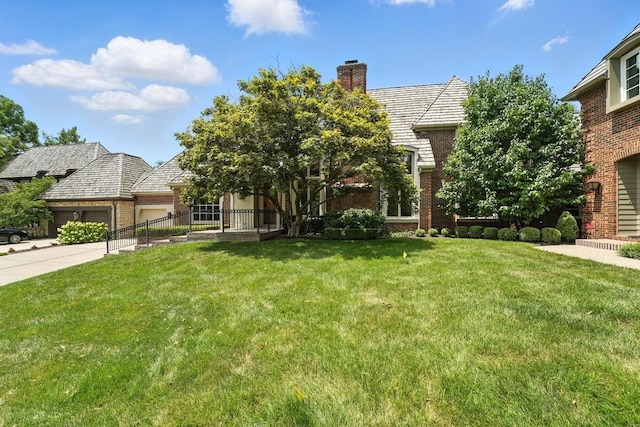 28 Le Mans Ct, Prairie Village, KS 66208 - view of front of home featuring an attached garage, brick siding, a chimney, and a front yard