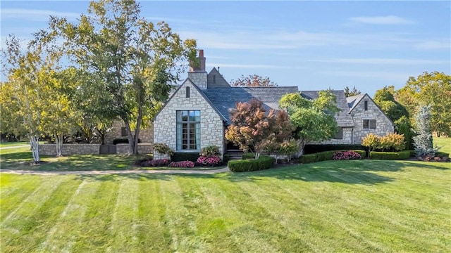 10400 Howe Dr, Leawood, KS 66206 - tudor house featuring stone siding, a front yard, and a chimney