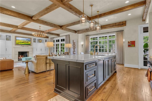 10400 Howe Dr, Leawood, KS 66206 - kitchen with light wood-style floors, beamed ceiling, a chandelier, decorative light fixtures, and a warm lit fireplace