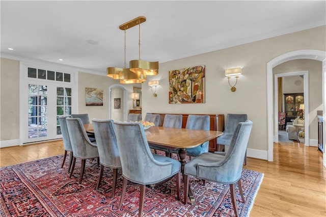 10400 Howe Dr, Leawood, KS 66206 - dining area featuring arched walkways, ornamental molding, light wood-style floors, and recessed lighting