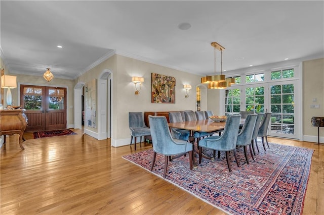 10400 Howe Dr, Leawood, KS 66206 - dining space with arched walkways, ornamental molding, light wood-style floors, healthy amount of natural light, and recessed lighting