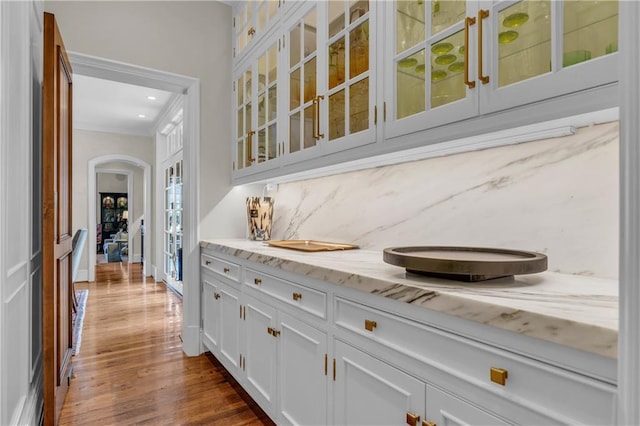 10400 Howe Dr, Leawood, KS 66206 - bar featuring arched walkways, dark wood-type flooring, backsplash, recessed lighting, and ornamental molding