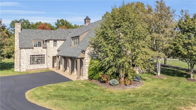 10400 Howe Dr, Leawood, KS 66206 - view of front of property with stone siding, a garage, driveway, a front yard, and a chimney