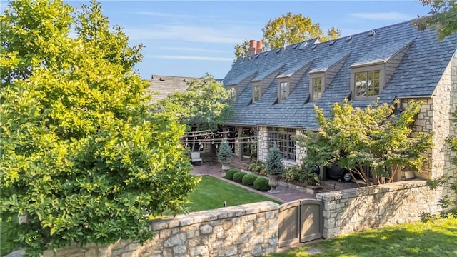 10400 Howe Dr, Leawood, KS 66206 - view of property exterior featuring a high end roof, a chimney, and stone siding