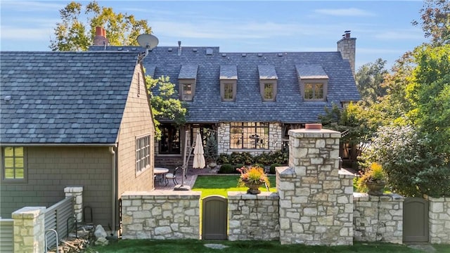 10400 Howe Dr, Leawood, KS 66206 - view of front of house with a chimney, a patio, a high end roof, and stone siding