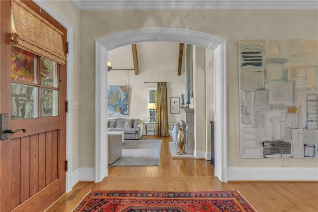10400 Howe Dr, Leawood, KS 66206 - foyer entrance with arched walkways, wood finished floors, healthy amount of natural light, and beam ceiling