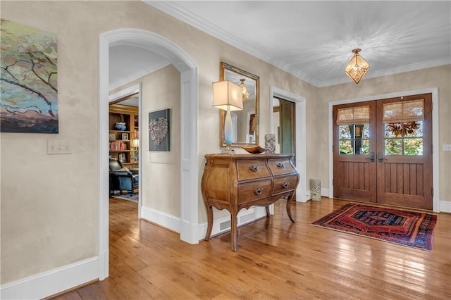 10400 Howe Dr, Leawood, KS 66206 - foyer entrance featuring light wood finished floors, arched walkways, ornamental molding, and french doors