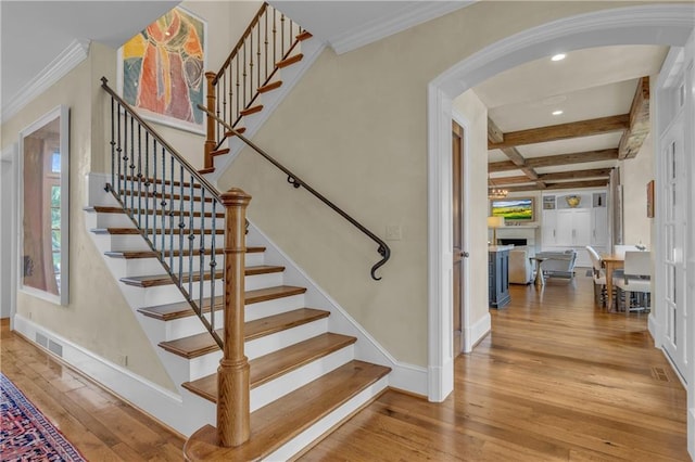10400 Howe Dr, Leawood, KS 66206 - staircase featuring arched walkways, hardwood / wood-style floors, beamed ceiling, a fireplace, and coffered ceiling