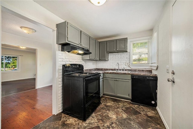 707 N Forest Ave, Independence, MO 64050 - kitchen featuring black appliances, under cabinet range hood, dark countertops, backsplash, and gray cabinets