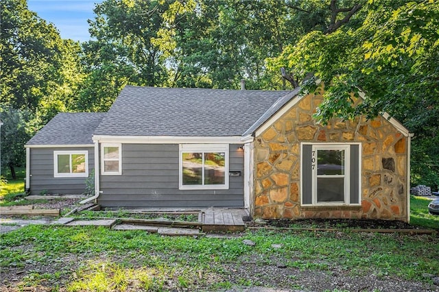 707 N Forest Ave, Independence, MO 64050 - view of front of house featuring stone siding, roof with shingles, and a front yard