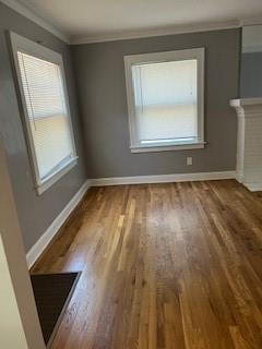 809 W Gregory Blvd, Kansas City, MO 64114 - unfurnished living room featuring wood finished floors and ornamental molding