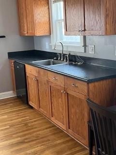 809 W Gregory Blvd, Kansas City, MO 64114 - kitchen featuring dark countertops, light wood-style floors, brown cabinets, and dishwasher