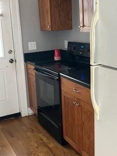 809 W Gregory Blvd, Kansas City, MO 64114 - kitchen featuring black electric range oven, freestanding refrigerator, brown cabinetry, and wood finished floors