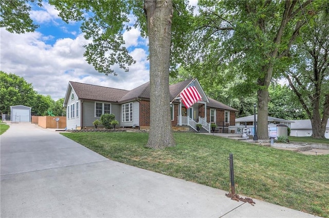2508 N Mcbride Ave, Sugar Creek, MO 64050 - view of front facade featuring an outbuilding, driveway, and brick siding