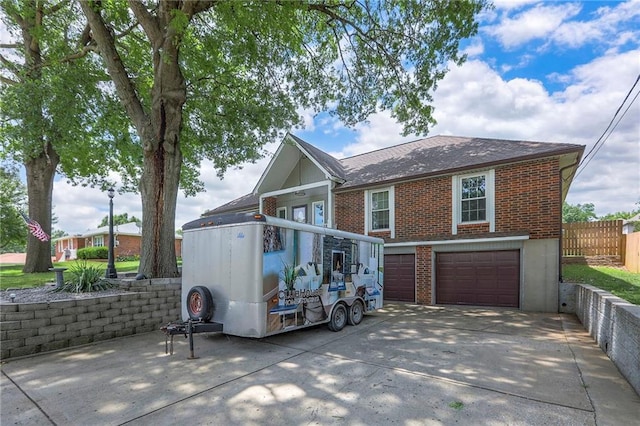 2508 N Mcbride Ave, Sugar Creek, MO 64050 - back of house featuring driveway, an attached garage, brick siding, and roof with shingles