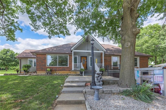 2508 N Mcbride Ave, Sugar Creek, MO 64050 - view of front of home with a front yard, brick siding, and a shingled roof