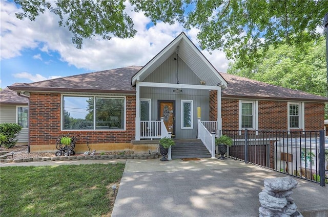 2508 N Mcbride Ave, Sugar Creek, MO 64050 - view of front of house featuring brick siding, covered porch, and roof with shingles