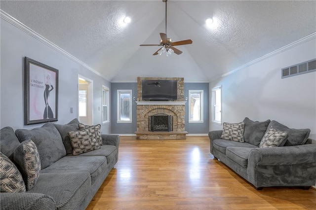 2508 N Mcbride Ave, Sugar Creek, MO 64050 - living room with a ceiling fan, light wood finished floors, a textured ceiling, a fireplace, and healthy amount of natural light