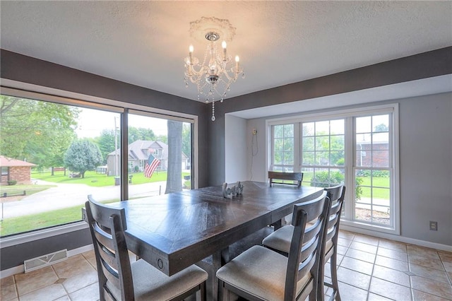 2508 N Mcbride Ave, Sugar Creek, MO 64050 - dining room featuring a chandelier, light tile patterned flooring, healthy amount of natural light, and a textured ceiling