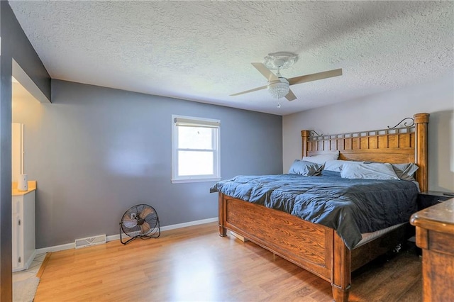 2508 N Mcbride Ave, Sugar Creek, MO 64050 - bedroom featuring wood finished floors, a textured ceiling, and ceiling fan