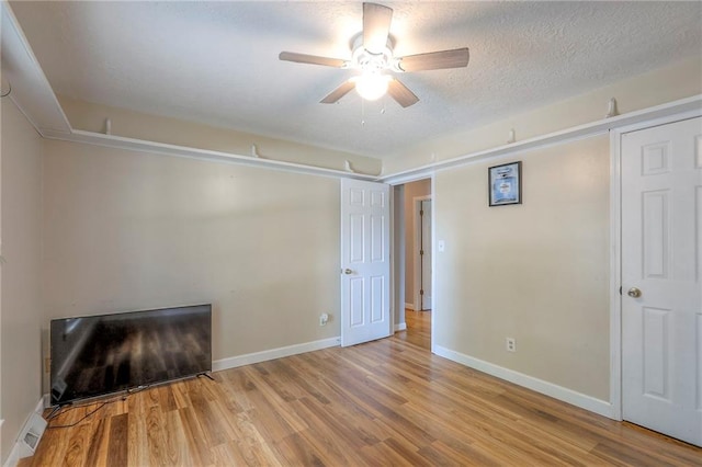 2508 N Mcbride Ave, Sugar Creek, MO 64050 - unfurnished living room with ceiling fan, wood finished floors, and a textured ceiling