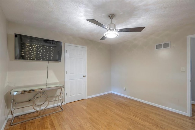 2508 N Mcbride Ave, Sugar Creek, MO 64050 - unfurnished bedroom featuring wood finished floors, a textured ceiling, and ceiling fan