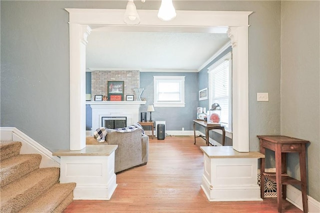 2517 Felix St, Saint Joseph, MO 64501 - living room with crown molding, light wood finished floors, a fireplace, a textured wall, and stairs