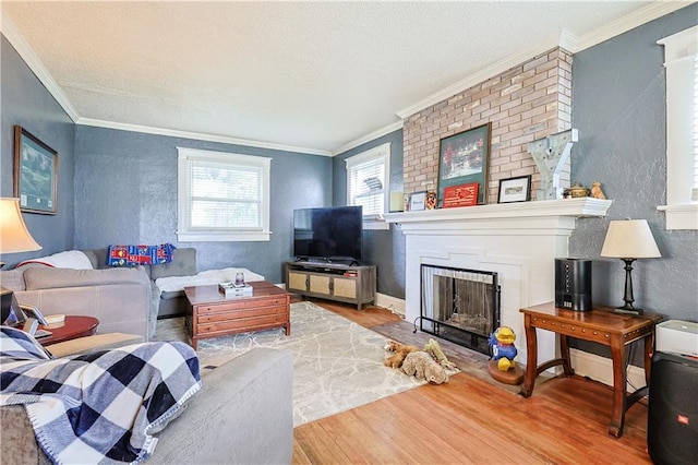 2517 Felix St, Saint Joseph, MO 64501 - living room with wood finished floors, a textured wall, a brick fireplace, ornamental molding, and a textured ceiling