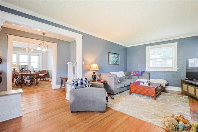 2517 Felix St, Saint Joseph, MO 64501 - living room featuring ornamental molding, wood finished floors, a chandelier, and decorative columns