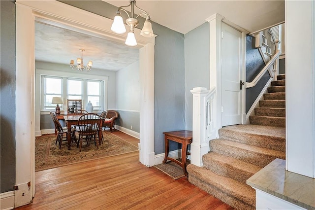 2517 Felix St, Saint Joseph, MO 64501 - dining space featuring a chandelier, light wood-style flooring, and stairs