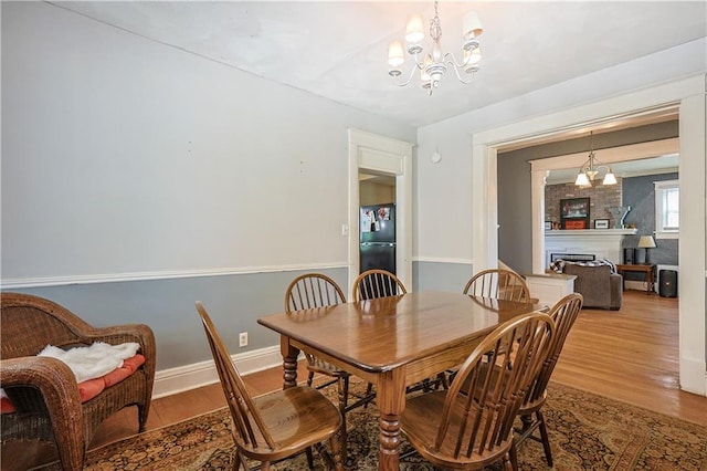 2517 Felix St, Saint Joseph, MO 64501 - dining room featuring wood finished floors, a chandelier, and a fireplace