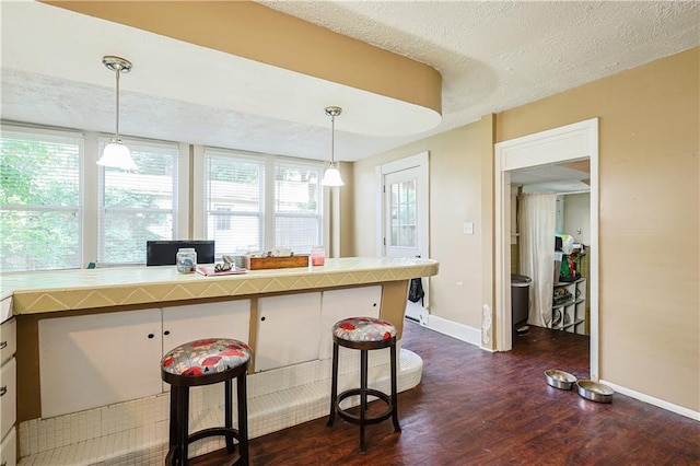 2517 Felix St, Saint Joseph, MO 64501 - kitchen featuring dark wood finished floors, pendant lighting, a textured ceiling, and light countertops