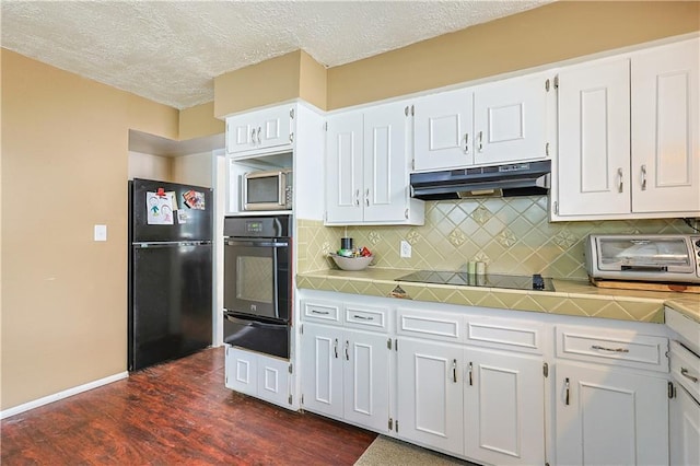 2517 Felix St, Saint Joseph, MO 64501 - kitchen with black appliances, under cabinet range hood, a warming drawer, light countertops, and white cabinets