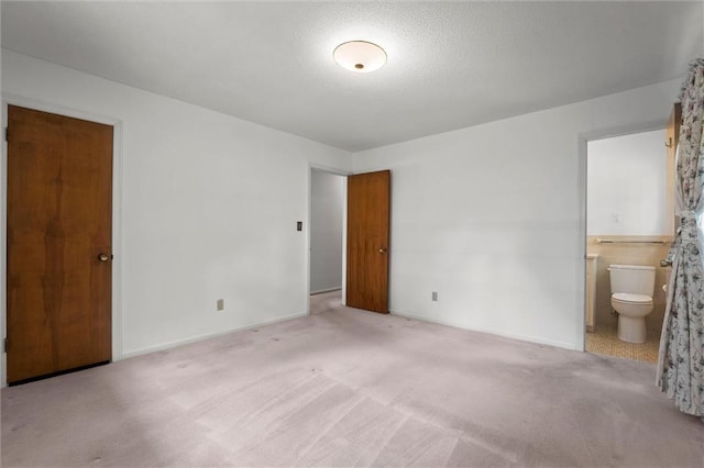 3300 W 93rd St, Leawood, KS 66206 - unfurnished bedroom with carpet flooring, ensuite bathroom, and a textured ceiling