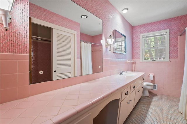 3300 W 93rd St, Leawood, KS 66206 - bathroom featuring wallpapered walls, tile walls, vanity, tile patterned floors, and wainscoting