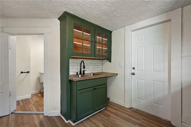 422 N Thompson St, Kansas City, KS 66101 - bar area with wood finished floors, a textured ceiling, and backsplash