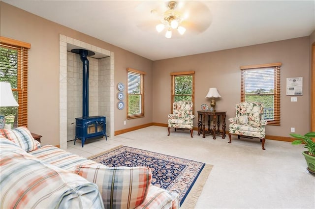 731 E 1100th Rd, Baldwin City, KS 66006 - living room featuring plenty of natural light, a wood stove, a ceiling fan, and carpet flooring